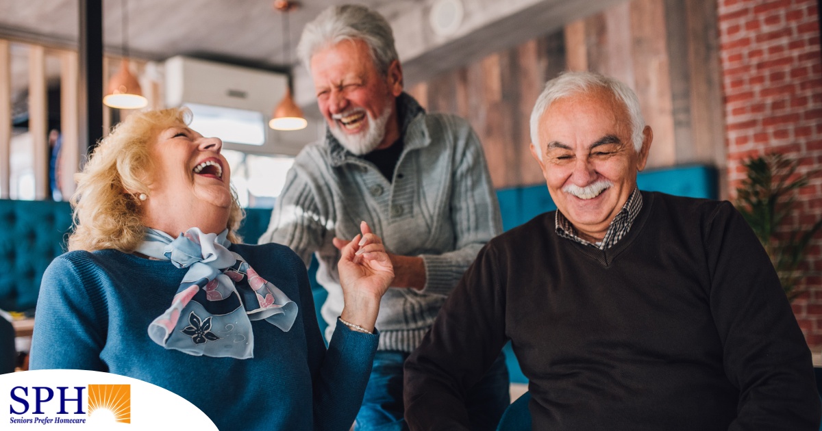 Older adults laugh and enjoy each other’s company representing how socialization can help seniors.