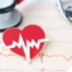 A heart symbol with an electrocardiogram line, an electrocardiogram sheet, and a stethoscope represents heart health.